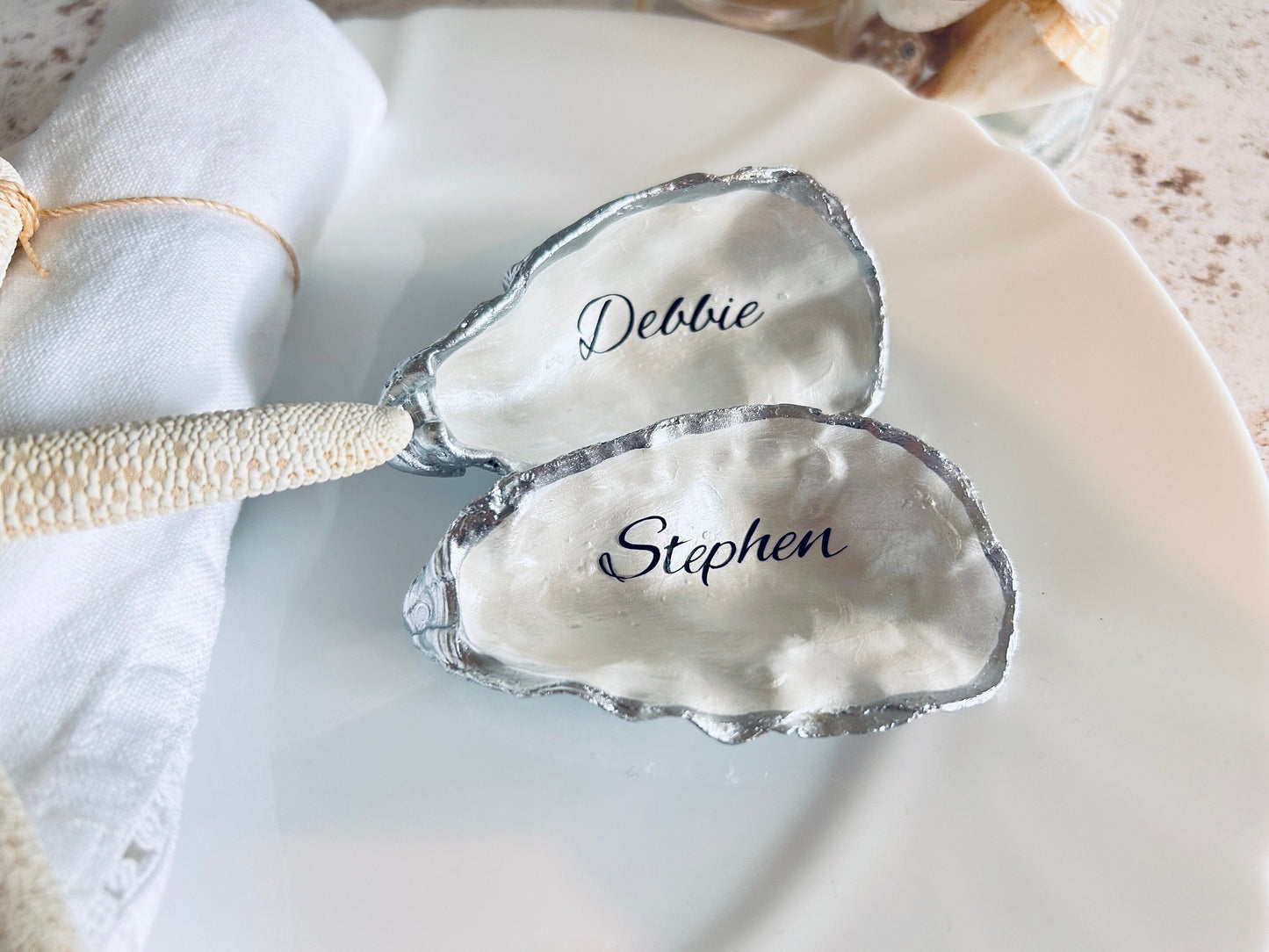 Oyster Shell Wedding Place Card and Favour. Personalised place names for your beach wedding decor. Silver coastal shell place settings.