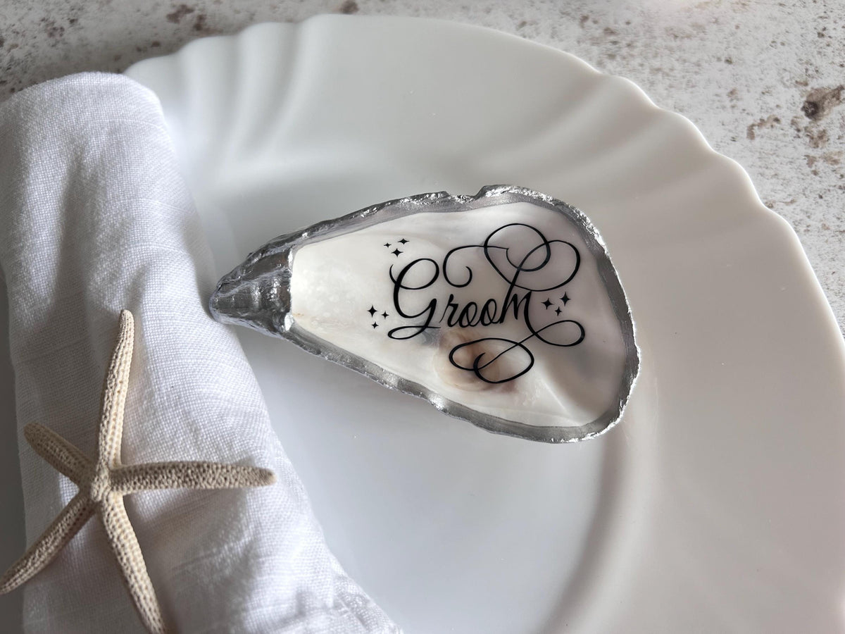 A oyster shell with a silver rim. The shell can have personalisation in differing calligraphy and different colours.