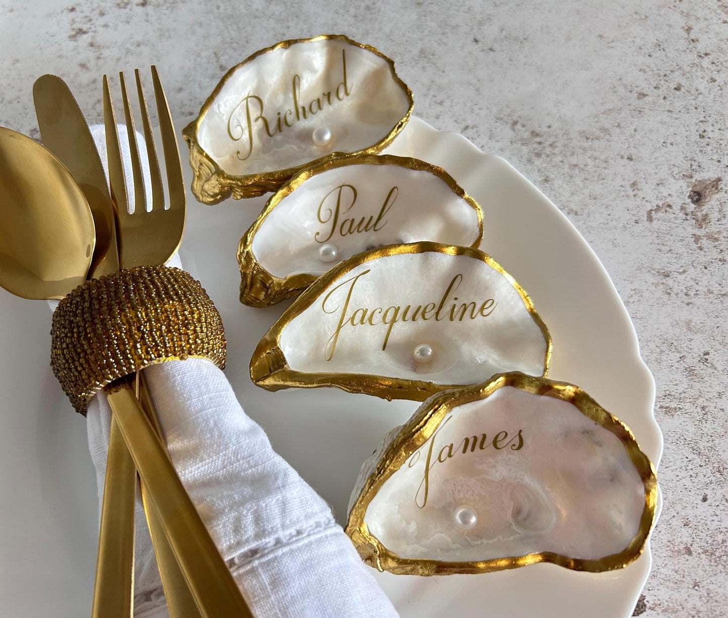 These natural oyster shells place names will add a touch of sophisticated luxury to your beach inspired wedding.  Finished in a luxurious antique gold on the rims and the inside and underside have been left natural ready to personalise with your guests names.