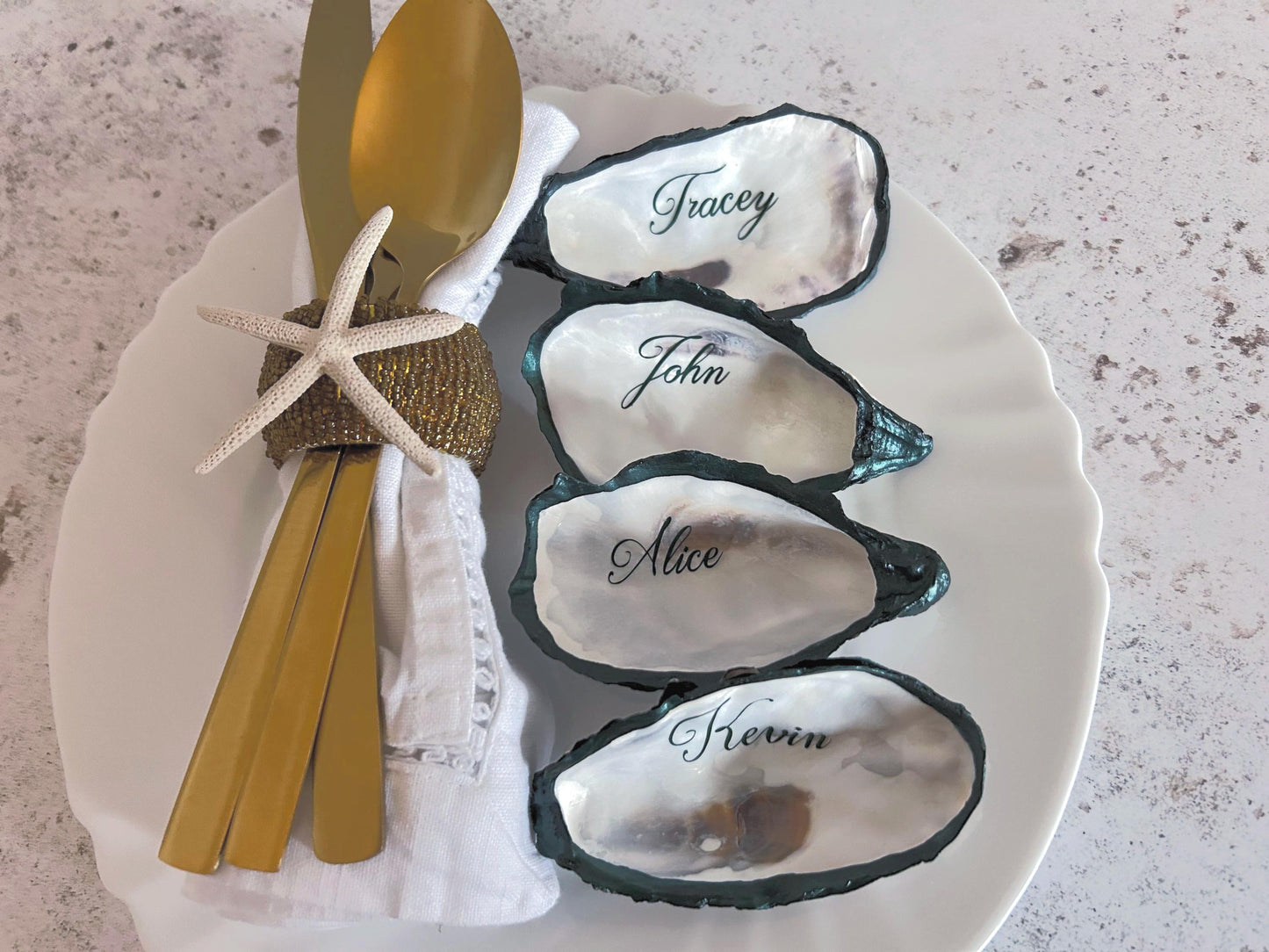 natural oyster shells with forest green painted esges and personalised in a script font in forest screen.