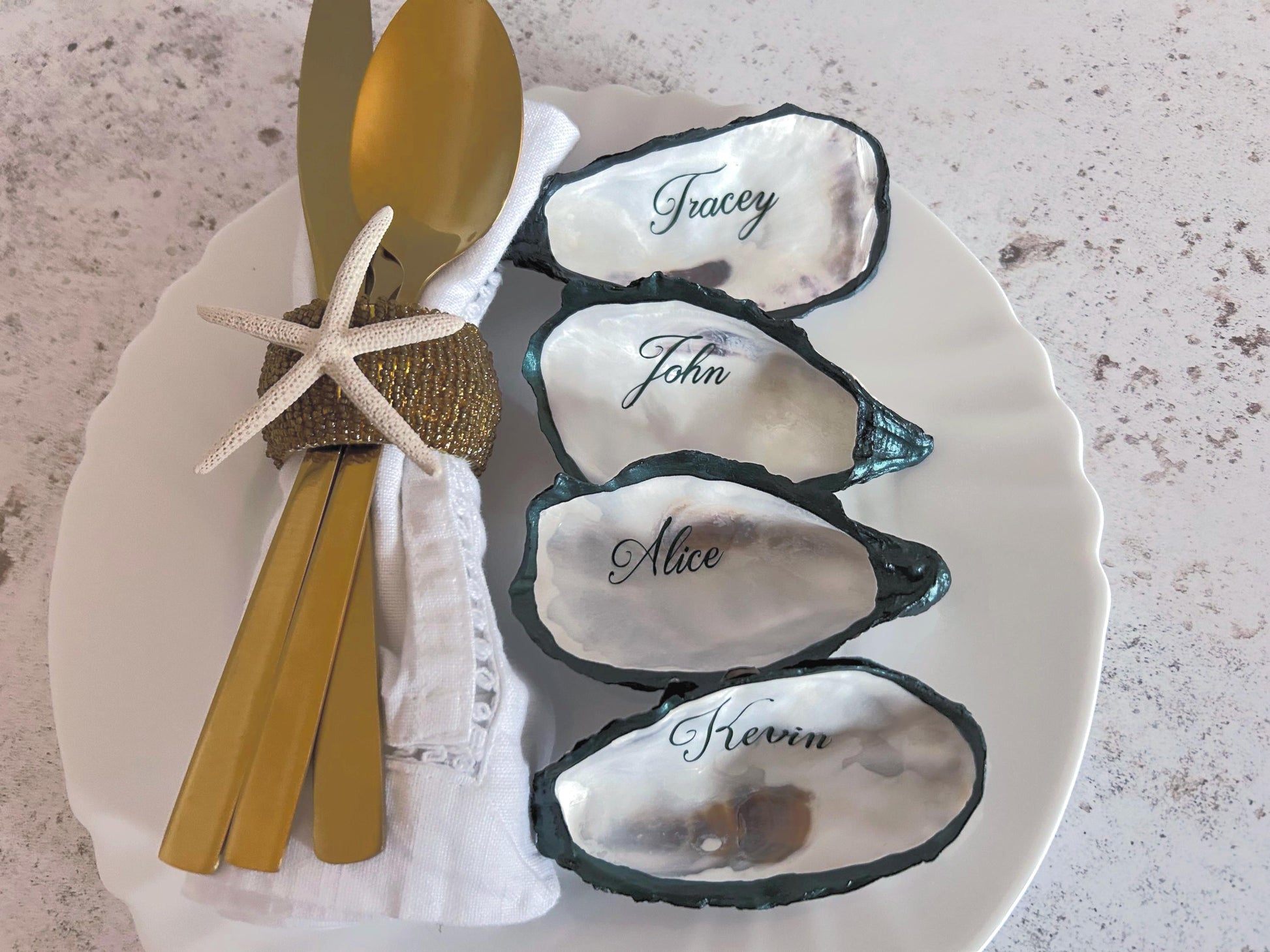 natural oyster shells with forest green painted esges and personalised in a script font in forest screen.