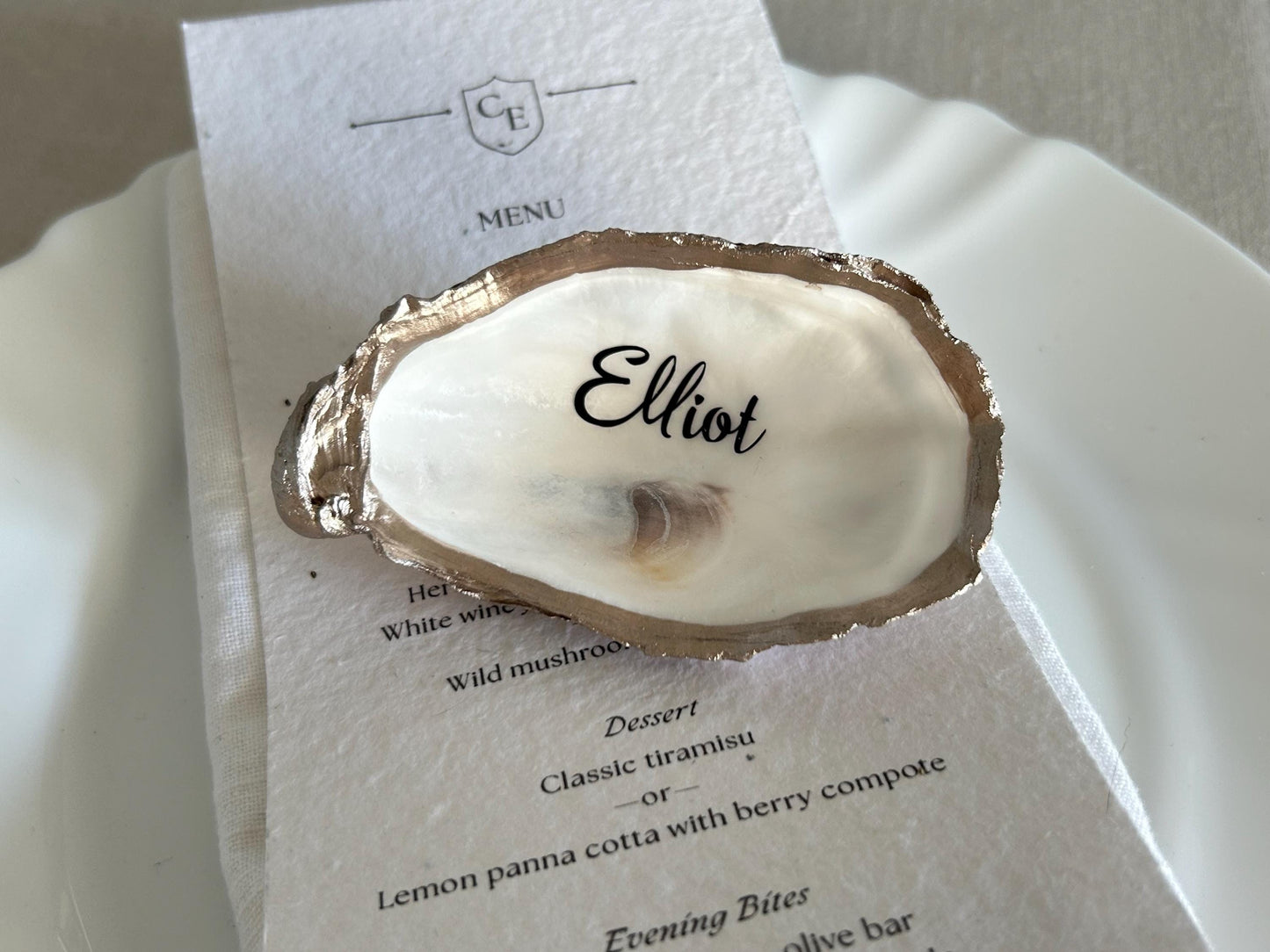 An oyster shell place card holder with a gold-coloured edge