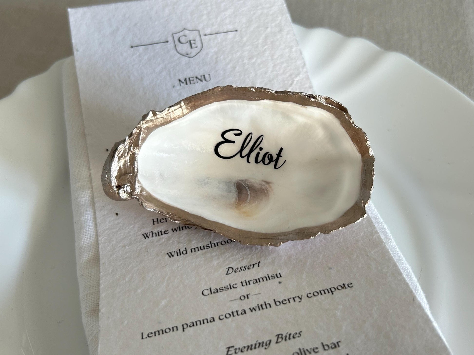 An oyster shell place card holder with a gold-coloured edge