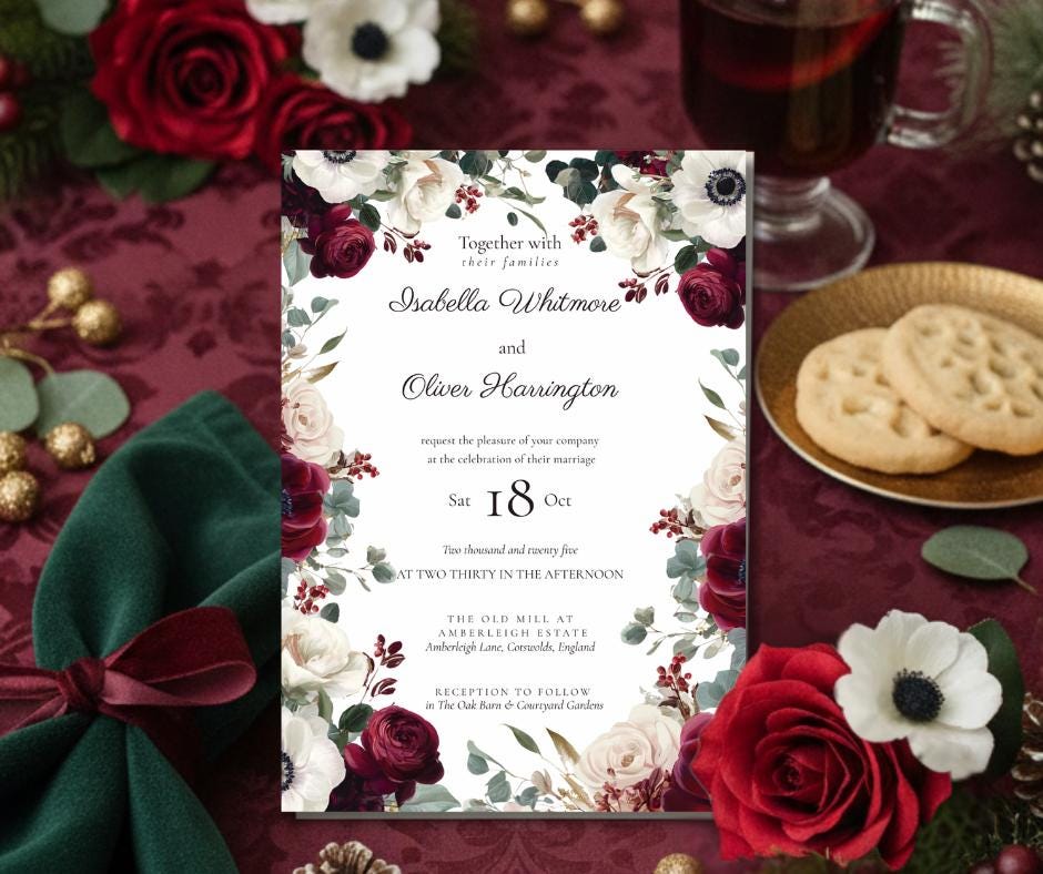 A wedding invitation with floral detailing, displaying the names. The invitation is framed by burgundy and white flowers, with the date and details